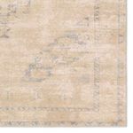 Zoomed-in view of the corner showing faded traditional border and medallion area in muted tan and blue