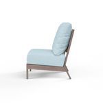 Side profile of Laguna Armless Club chair showing angled back and driftwood finish frame with light blue cushions