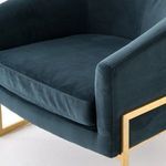 Close-up of the lower brass frame with curved base and vertical supports under velvet seat