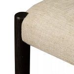 Close-up of textured carbon-toned cotton-linen dining chair seat fabric and adjacent carbon wood frame leg
