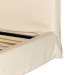 Side view of slipcovered footboard with fabric draped over edges and floor-length skirt