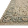Low angled side view highlighting the rug’s vintage texture and blue-green floral border