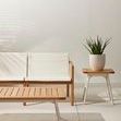 Kaplan Wooden Outdoor Sofa styled in minimalist setting with wooden side table and plant