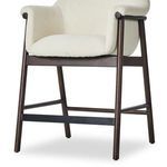 Close-up side angle showing stool's dark wood frame and black footrest