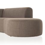 Close view of sectional's rounded front chaise area with smooth fabric surface.