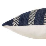 Close-up of pillow corner showing woven striped front and smooth ivory back fabric