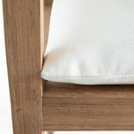 Close-up of white cushion fabric and teak seat edge from side angle