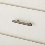 Close-up detail of single metal drawer handle with hammered texture in dark metal finish