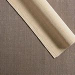 Rug edge rolled back revealing non-slip backing in contrasting darker brown tone