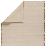 Top corner of rug lifted to reveal plain backing fabric in neutral beige