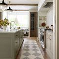Long runner version of Francis rug laid in a kitchen with cream and sage cabinets and brass hardware