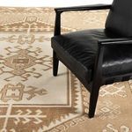 Partial view of Enver rug under a black leather chair highlighting the rug’s pattern and texture