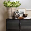 Trophy Basket styled with white flowers on a black cabinet with decor accents