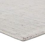 Close-up of rug edge showing thick, soft cut and loop polyester pile with cream and gray tones