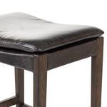 Close-up of black top-grain leather cushion on Aya Stool showing texture and stitching