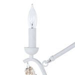Close-up of a single lit candle-base light with bulb and stone bead decoration hanging from a curved white metal arm