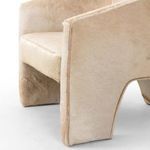 Close-up detail of front left arm and seat edge showing hair direction and stitching