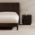 Nightstand styled next to matching ribbed black Acacia bed frame in neutral bedroom setting