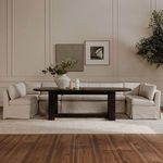 Banquette styled in a light neutral room with dark wooden dining table and decorative vases