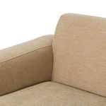 Seated area close-up showing smooth tan fabric upholstery on seat and inner arm