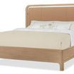 Side angle showing Banyon Bay bed's curved Desert Oak frame and padded leather headboard in Toast color