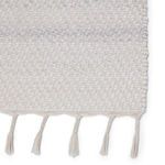 Detailed close-up of rug texture highlighting woven PET yarn and tassels
