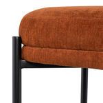 Close-up of the textured terra cotta cushion fabric and black metal frame connection detail