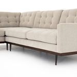 Straight angle view of right side armrest and button tufting on back cushions