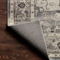 Corner flipped over revealing woven polyester backing and clean stitched edge on dark hardwood floor