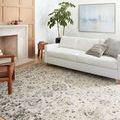 Estelle Ivory Stone Rug styled in a bright living room under a white sofa with wooden furniture