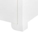 Close-up of bottom corner of Elina side table showing rounded leg design and white lacquered linen texture