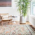 Elka Sky Multi rug in bright room setting with wooden floor, armchair, and large potted plant, showing rug scale