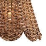 Close-up of scalloped bottom edge of woven rattan sconce shade with warm light glowing through