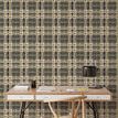Wallpaper applied in home office setting behind minimalist wooden desk and chair with table lamp and books