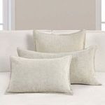natural shams displayed with rectangular and lumbar pillows on neutral sofa in bright room