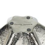 Underside of Pedicoat Metal Bowl showing brand stamp and protective pads on matte silver base