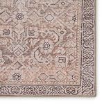 Rug viewed inside with grey pouf and small white and grey planter holding artificial grass