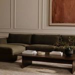 Rue Nook sectional styled in living room with dark wood coffee table, beige rug, and wall art