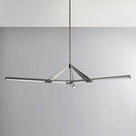Side view of chandelier hanging in room with gray wall background showing structure but lights off