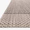 Close-up angled view showing the woven texture and tight stitching of the rug's edge