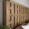 Close-up of wood grain and hammered metal corner accent on headboard’s fretwork design