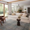 Charcoal plaid rug styled in a bright living room with white sofa, wooden beams, and natural light
