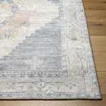 Detailed close-up of the rug’s edge showing low pile, machine woven texture, and subtle color variations