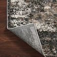 Corner of Estelle Charcoal Granite rug folded back showing woven backing and edge finish