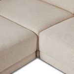 Tight close-up of sectional cushions meeting at seam with textured cream fabric