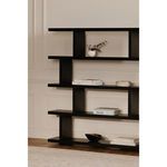 Black shelving unit featuring the Forde bowl styled among books and decorative objects