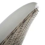 Detailed view of woven wicker texture and piping along top edge of white vinyl backrest