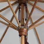 Close-up of wooden pulley system and ropes under cream canopy of Baska umbrella