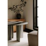 Room context showing Celia dining table next to window with black frame and part of beige upholstered chair visible