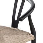 Detail of black teak rear leg and horizontal support rails under woven seat